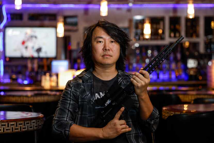 Encore Family Karaoke owner Jin Shin poses for a portrait with his semi-automatic AM-15 on...