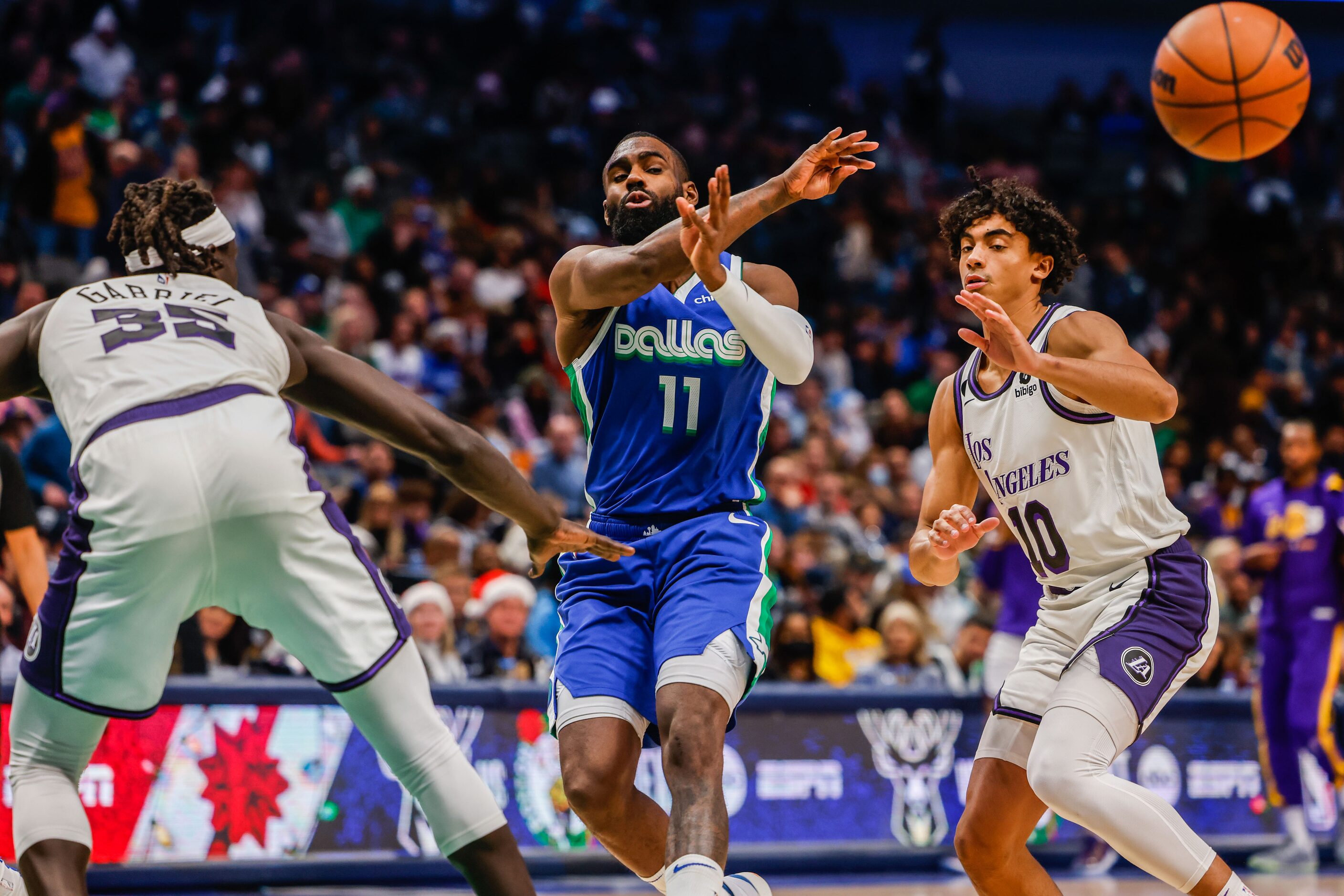 Dallas Mavericks forward Tim Hardaway Jr. (11) passes the basketball next to Los Angeles...