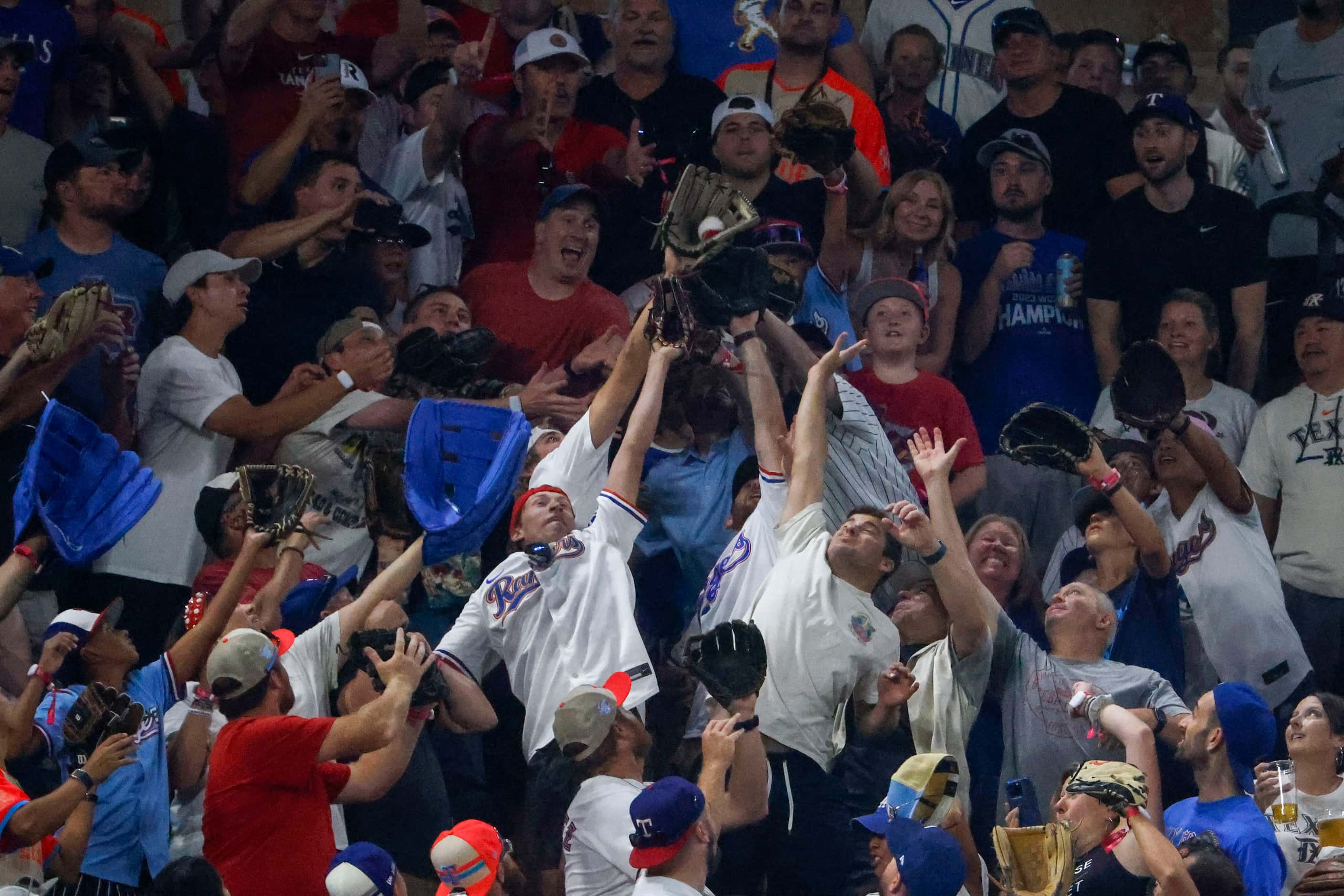 Crowd reaches to catch a homerun ball hit by Jose Ramirez, of the Cleveland Indians during...
