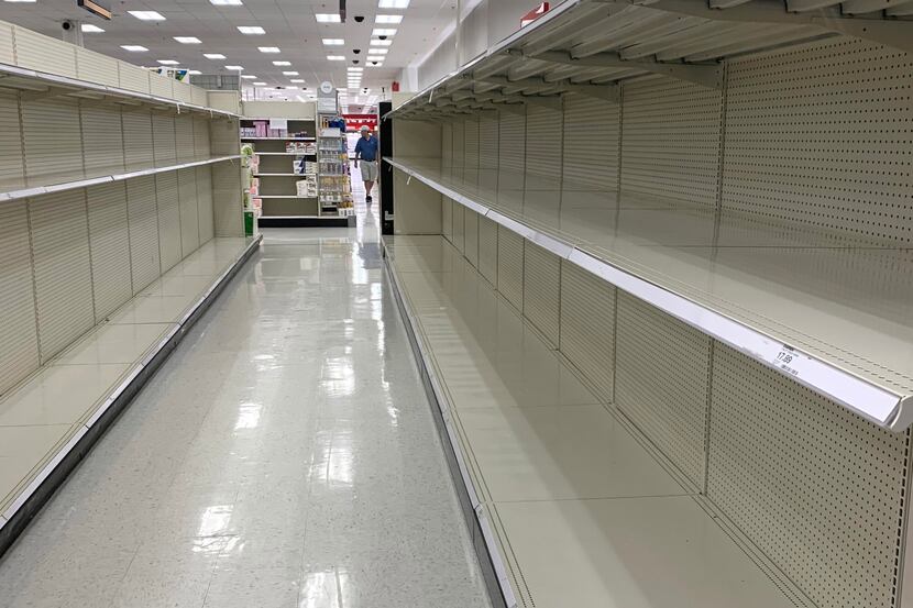 Shelves in the toilet paper aisle were bare on Thursday, March 12, 2020, after shoppers...