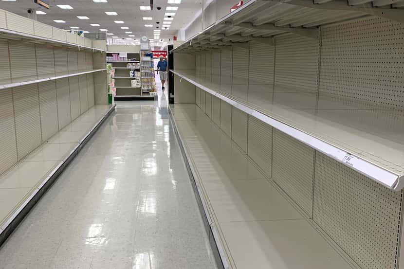 Shelves in the toilet paper aisle were bare on Thursday, March 12, 2020, after shoppers...