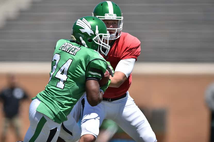 North Texas sophomore quarterback Connor Means (7) hands off the ball to junior running back...