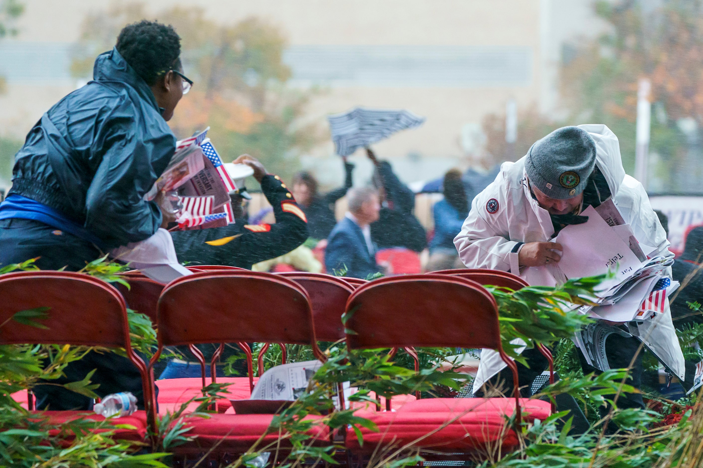 Organizers an spectators run for cover as wind gusts and rain buffet City Hall Plaza before...