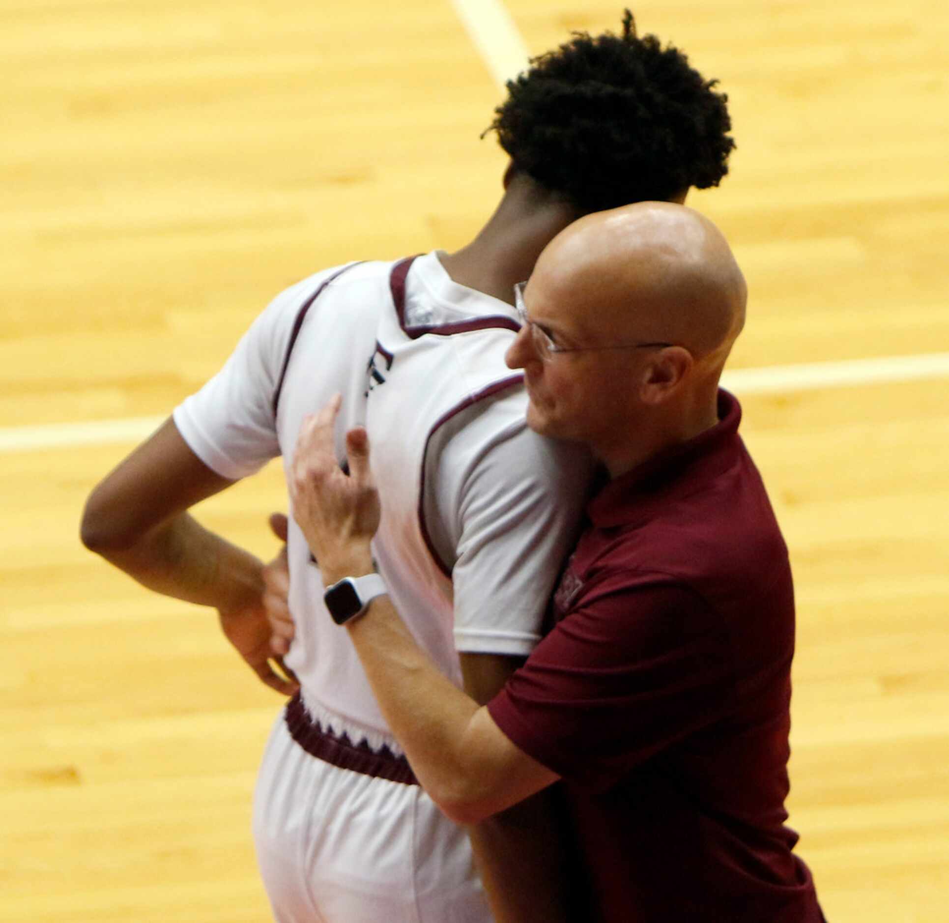 Mansfield Timberview head coach Duane Gregory shares a hug with Eyan Gooden (4) after the...