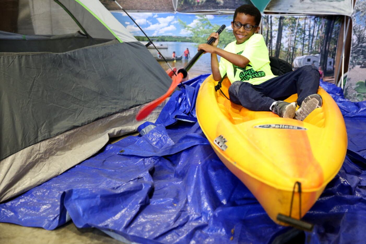 Evan Williams, 7, of McKinney, Texas, pretends to row a kayak during Earth Day Texas at Fair...