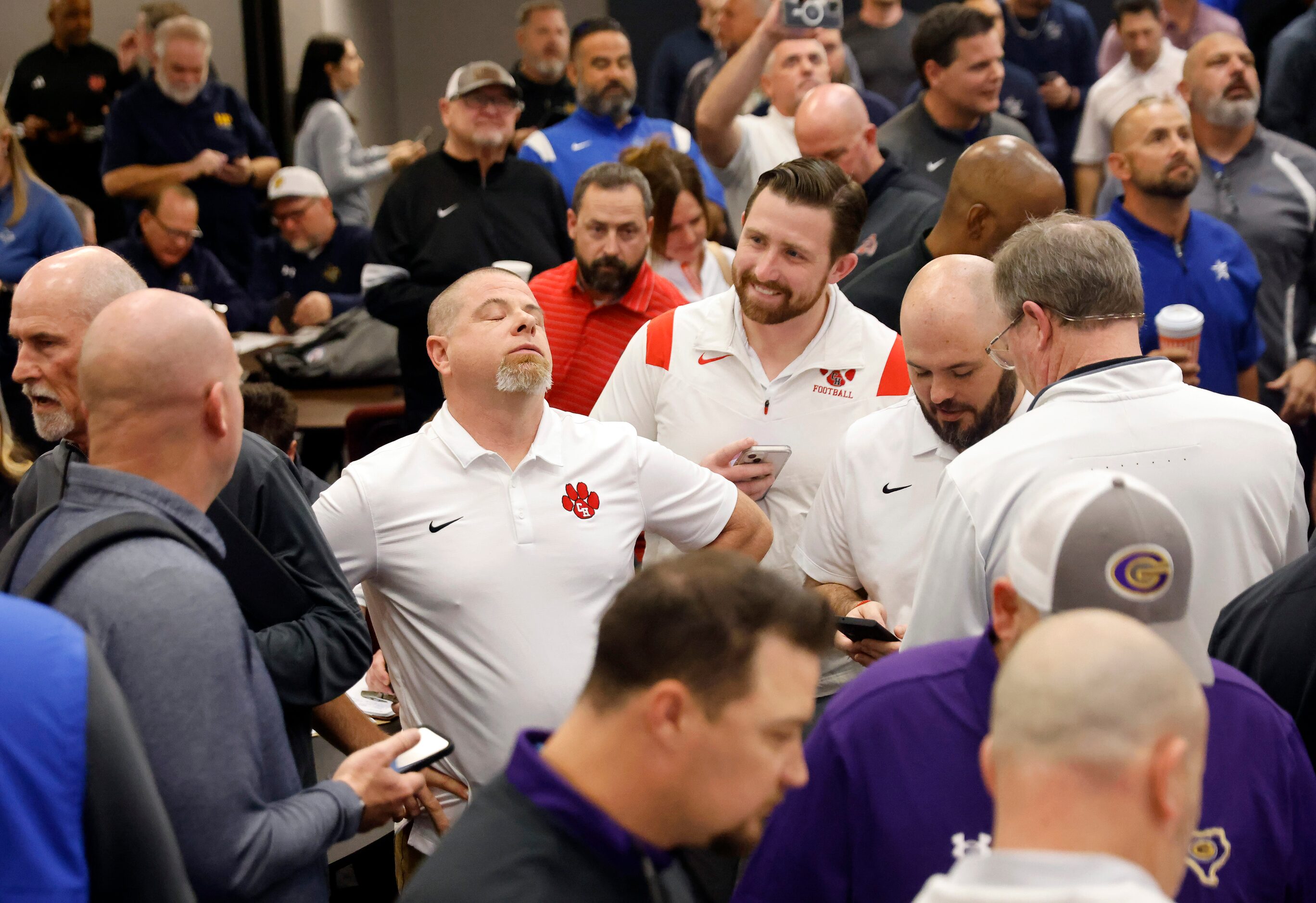 Colleyville Heritage head football coach Jerry Edwards (center, left ) reacts to seeing his...