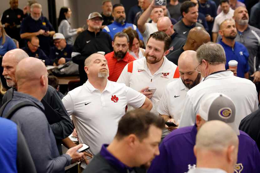 Colleyville Heritage head football coach Jerry Edwards (center, left ) reacts to seeing his...