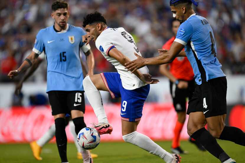 Ricardo Pepi de Estados Unidos controla el balón ante la presión del uruguayo Ronald Araujo...