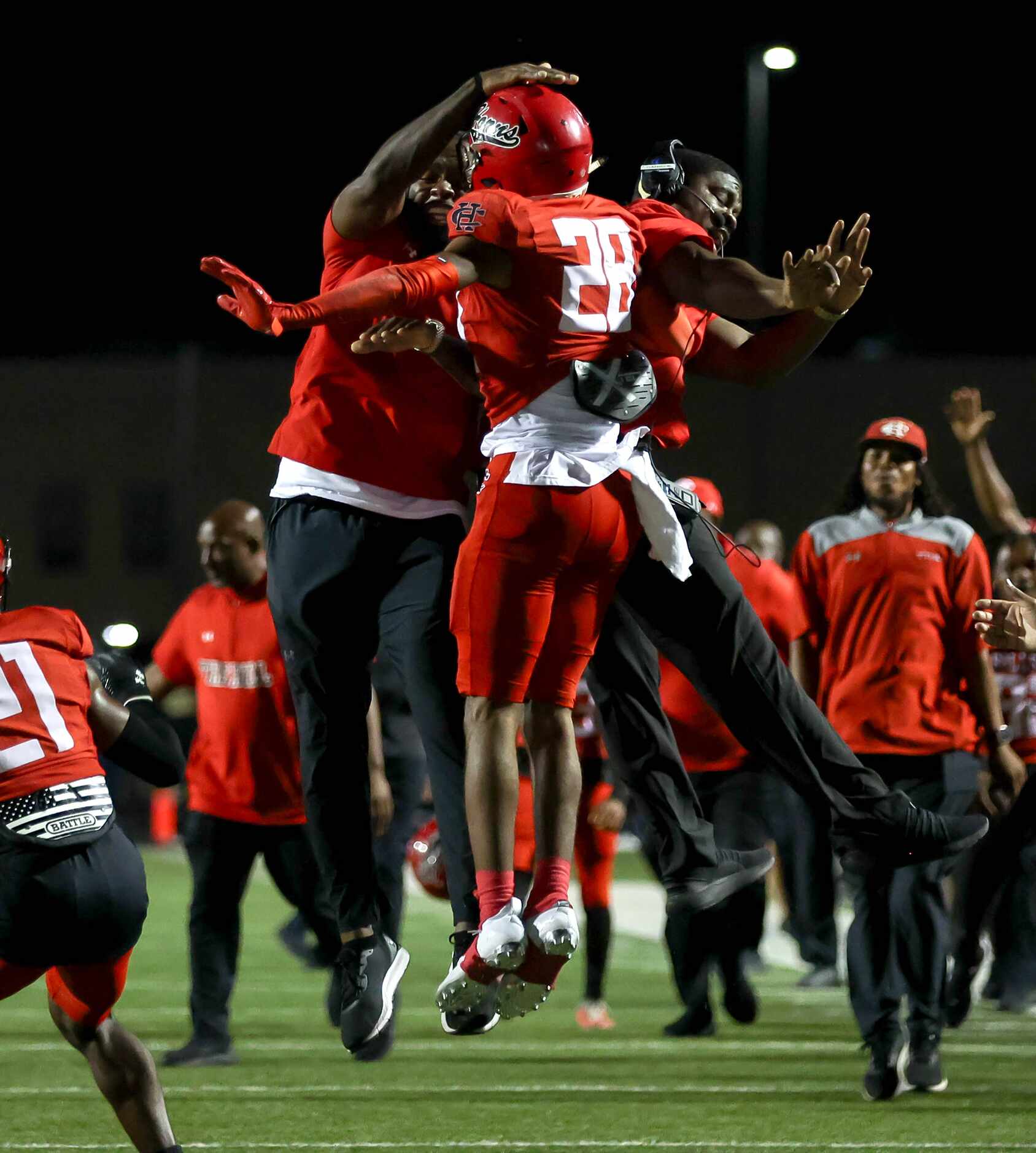 Cedar Hill strong safety Michael Parker (28) celebrates with his coach after getting an...