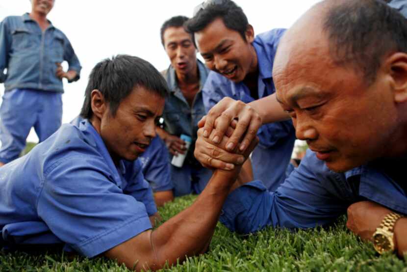 Chinese lantern workers Zhongquan He (left) and Xiquan Yuan compete in an arm wrestling...