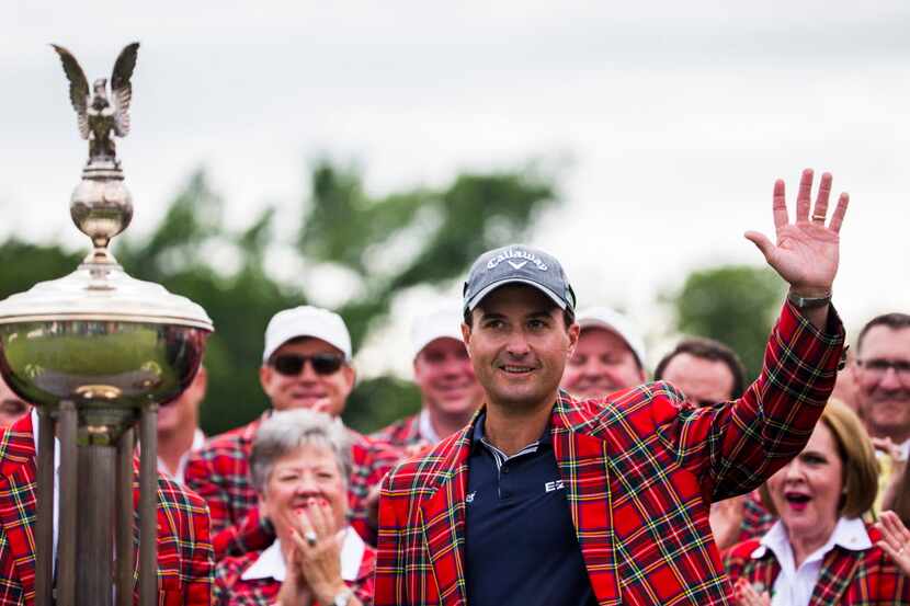 Kevin Kisner waves to fans standing next to the Leonard trophy after he won the Dean &...