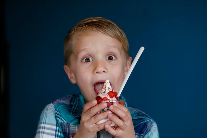 Henry McKibben, 6, of Dallas, eats ice cream before Cow Tipping Creamery officially opened...