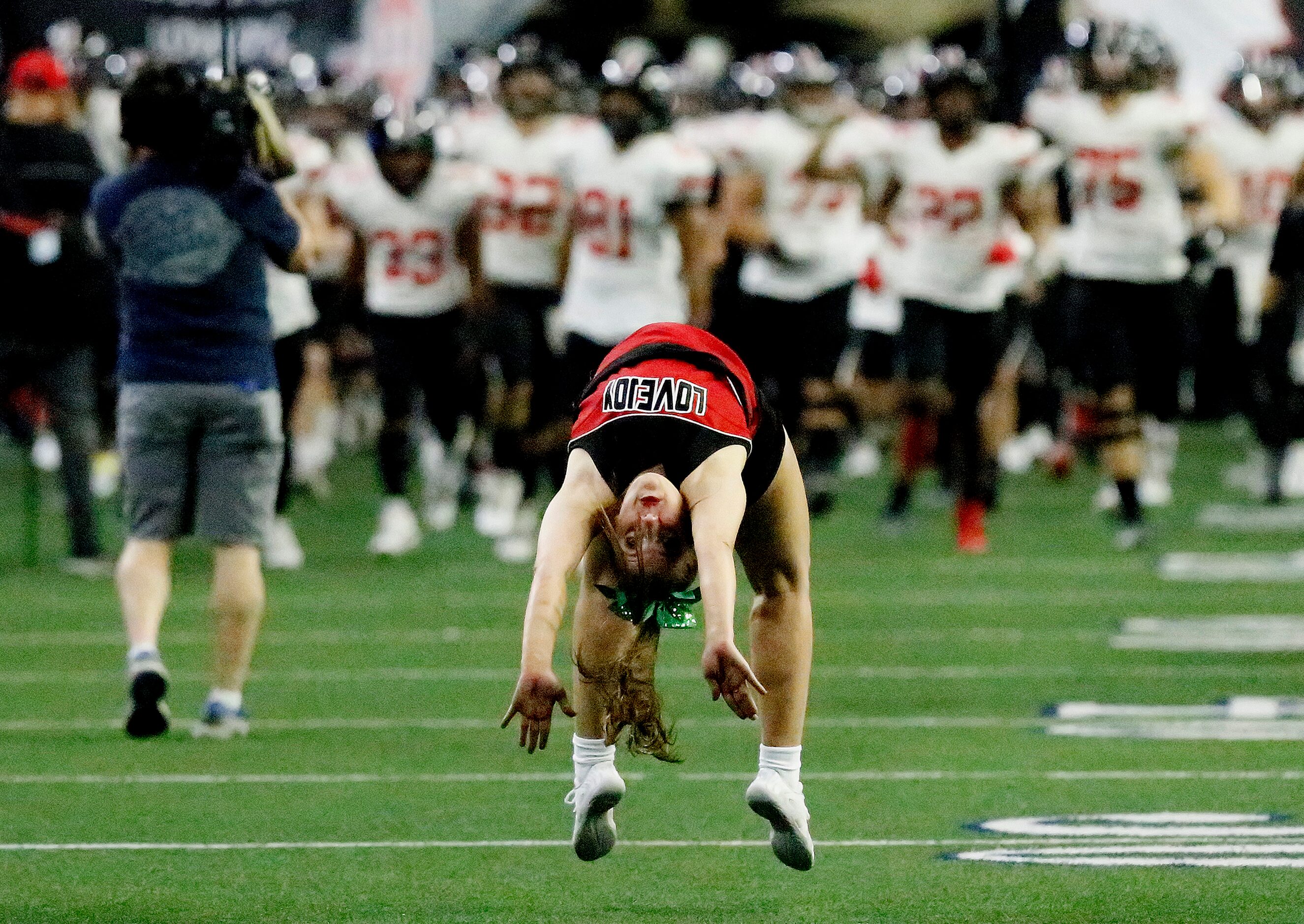 Lovejoy cheerleader Gabby Grazoli, 17, leads the varsity football team onto thefield before...