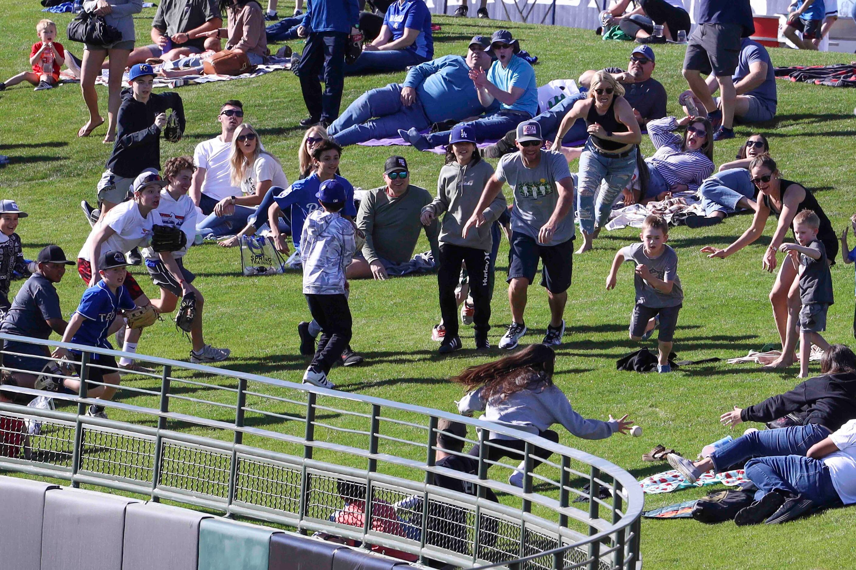 Fans run after a home run ball by Kansas City Royals during the ninth inning of a spring...