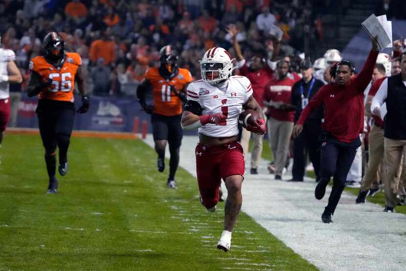 Wisconsin running back Chez Mellusi (1) runs away from Oklahoma State defensive tackle...