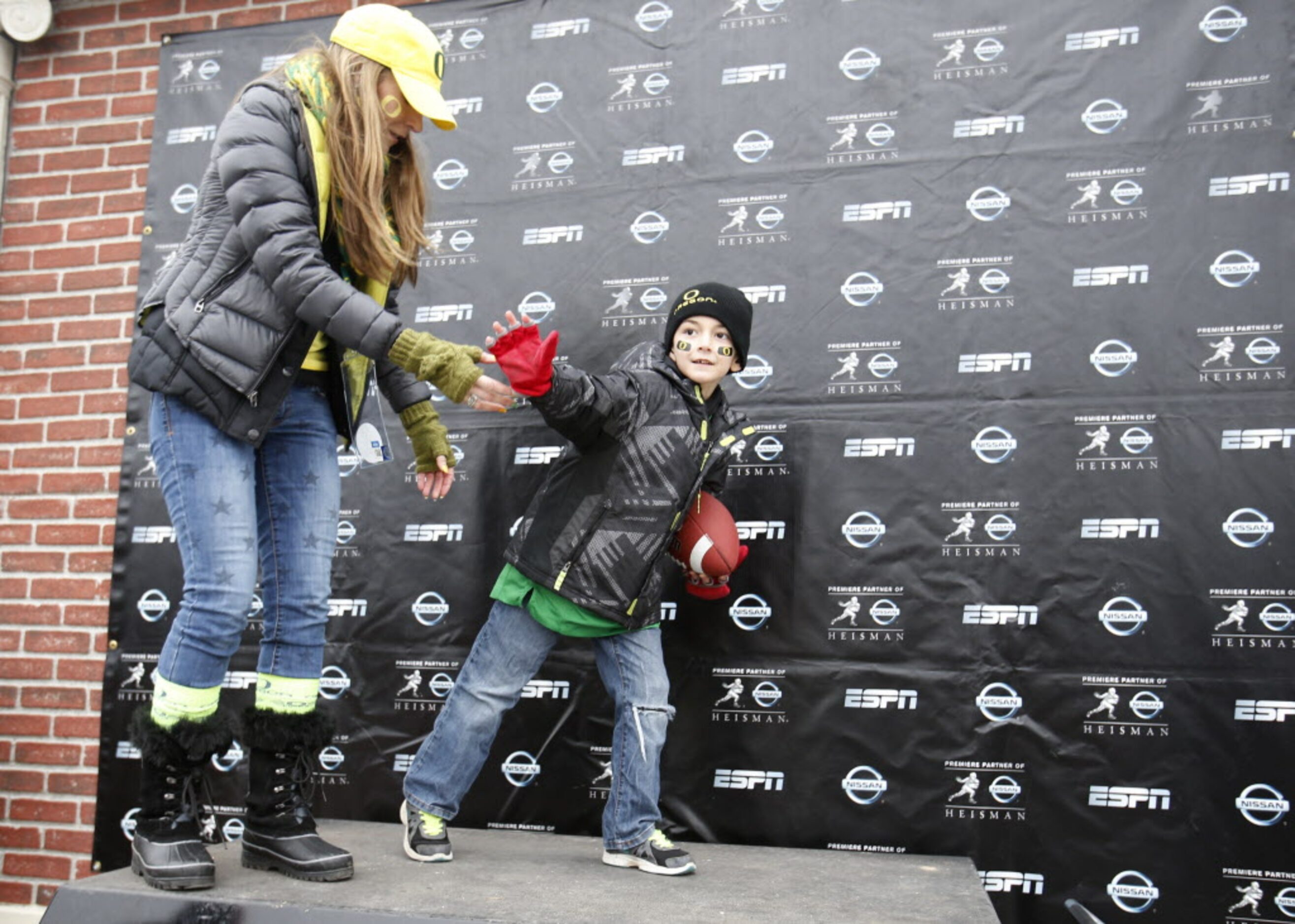 Cynthia Wirfs helps her son Grant Wirfs of Portland do the Heisman pose for a photo before a...