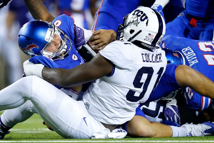 Southern Methodist Mustangs quarterback Ben Hicks (8) is sacked by TCU Horned Frogs...
