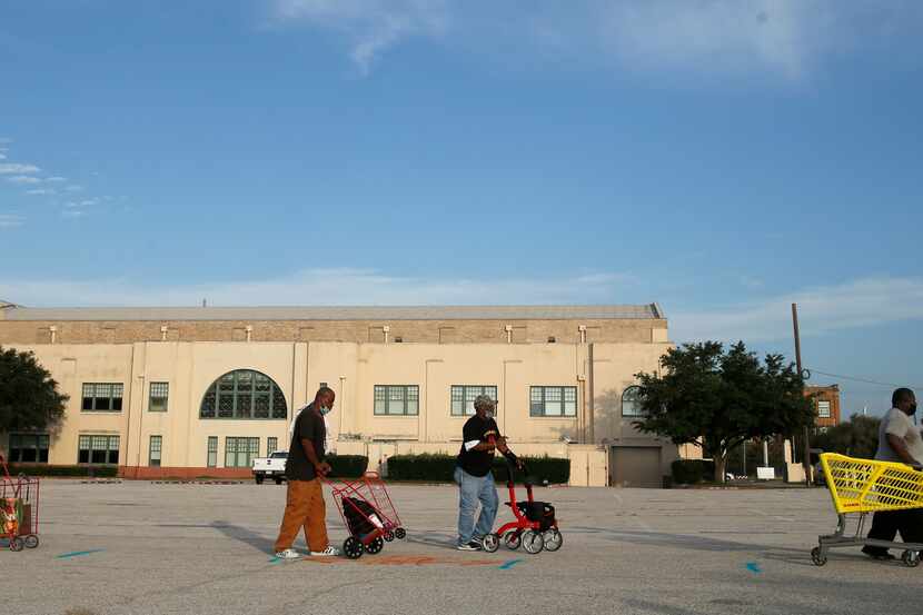 People wait in line at the walk-up section of the North Texas Food Bank's fourth free food...