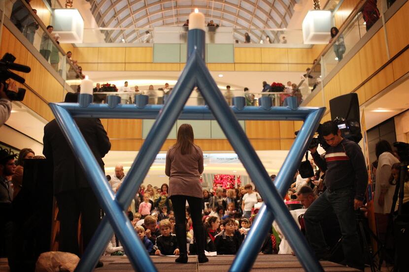 Families gathered to watch the ceremonial lighting of the community menorah at the Galleria.