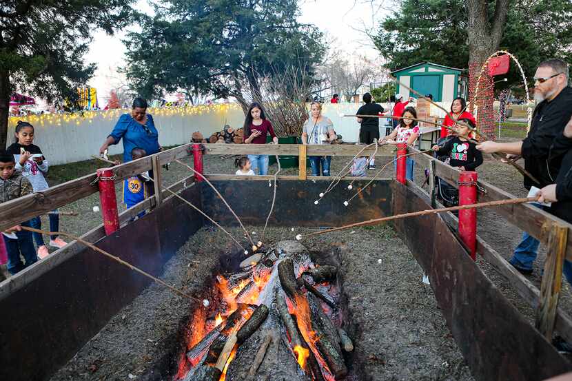 Festival-goers roast marshmallows at a previous year's Christmas in the Park, an annual...