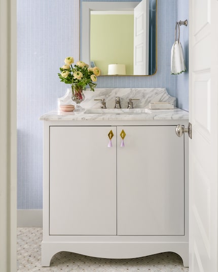 White bathroom vanity on tile floor with blue wall