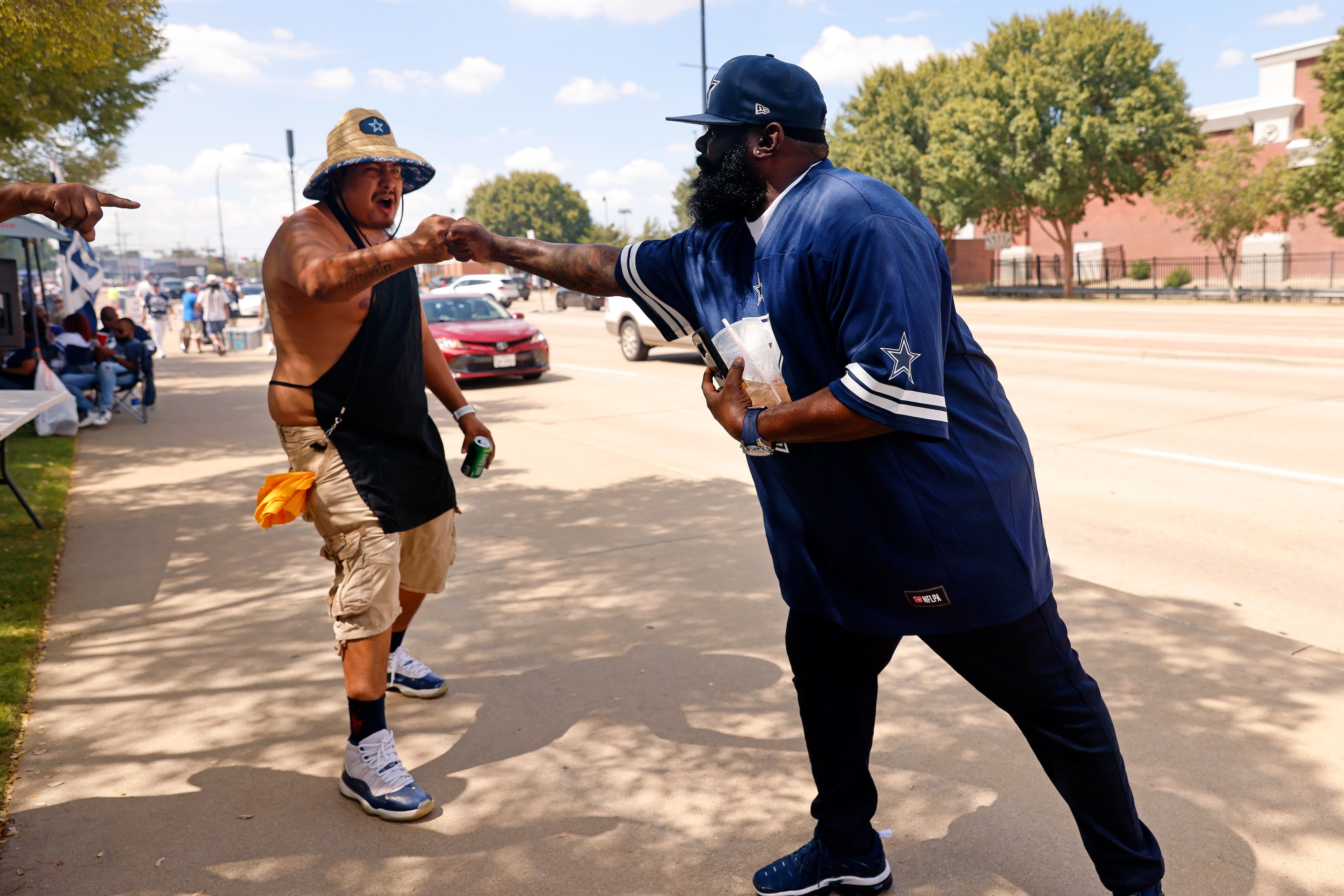 Dallas Cowboys fan Gerald Finklin (left) receives a fist bump from Hector Zapata of Amarillo...