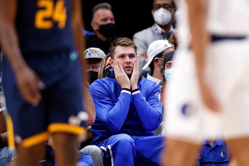 Dallas Mavericks guard Luka Doncic reacts to a second half play as he watches the game...
