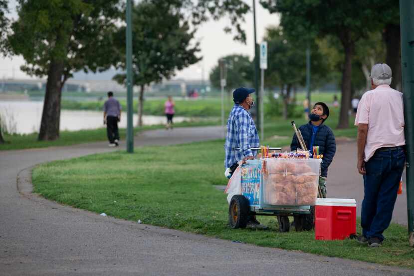 A paletero man waits for customers on the northern side of Bachman Lake Park.