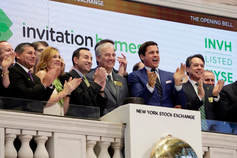 Invitation Homes president and CEO John Bartling Jr. (fourth from left) is applauded as he...