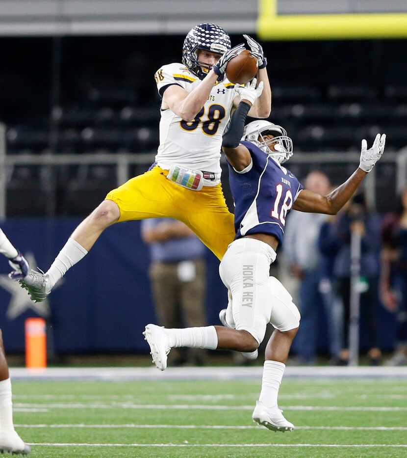 Highland Park's Cade Saustad (88) leaps over Manvel's Trent Gordon (18) for a reception...