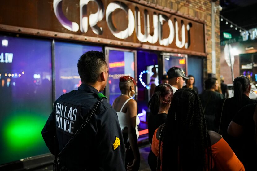 Dallas police Sgt. Boz Rojas walks through people on the sidewalk in front of Crowdus in...