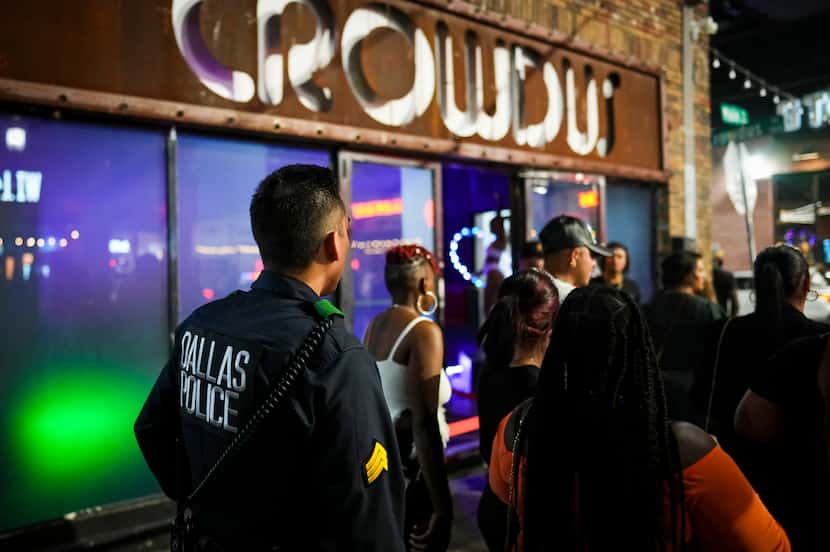 Dallas police Sgt. Boz Rojas walks through people on the sidewalk in front of Crowdus in...