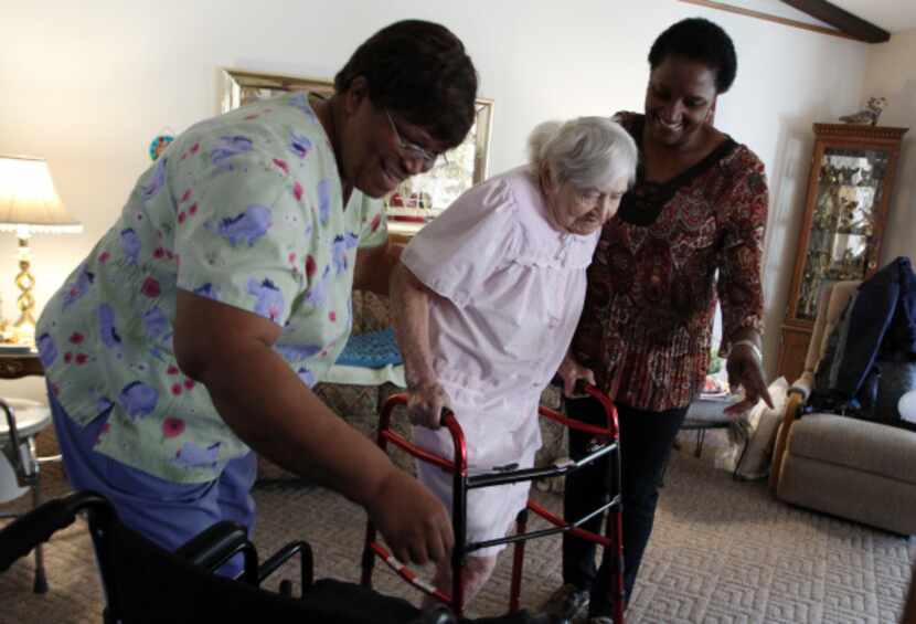 Caregivers Gloria Black, left, and Kandee Smith help Irene Maxa with household needs while...
