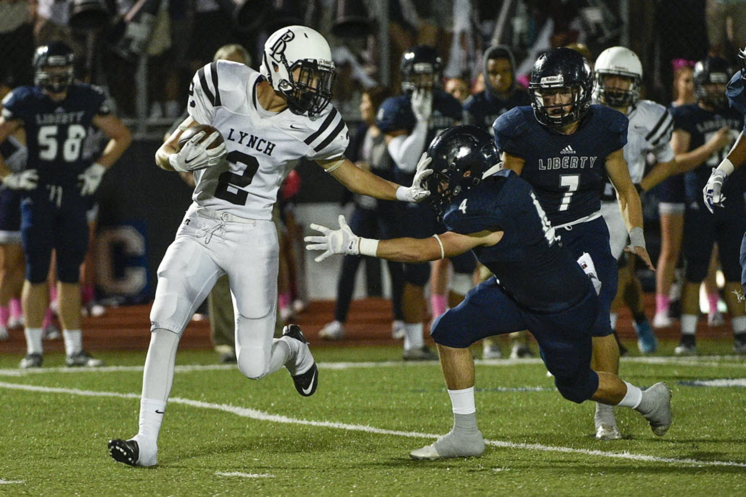 Bishop Lynch wide receiver Michael Brown (2) stiffarms Liberty's Nick Murray (4) during a...