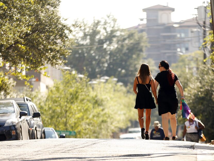 A couple walks leaves Lee Park following the Alan Ross Texas Freedom Parade on Cedar Springs...