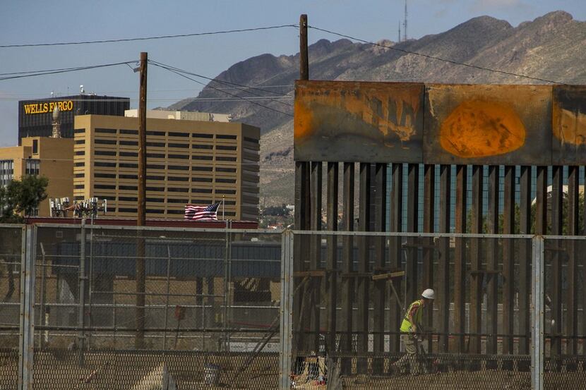 Workers in El Paso replace a section of the border fence next to the international border...