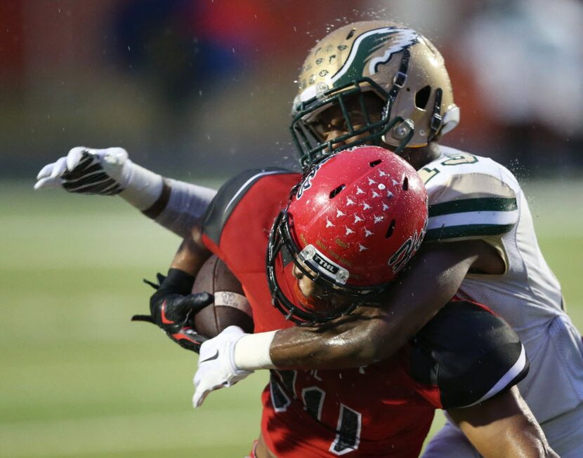 Cedar Hill's Kaegun Williams (24) is tackled by DeSoto's Isaiah Stewart (13) during the...