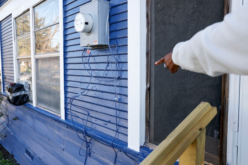 Zabrina Chism, 54, points to cables that were left hanging and painted over by contractors...