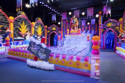 Colorful ice sculpture display centered around an ice slide with five lanes for guests to...