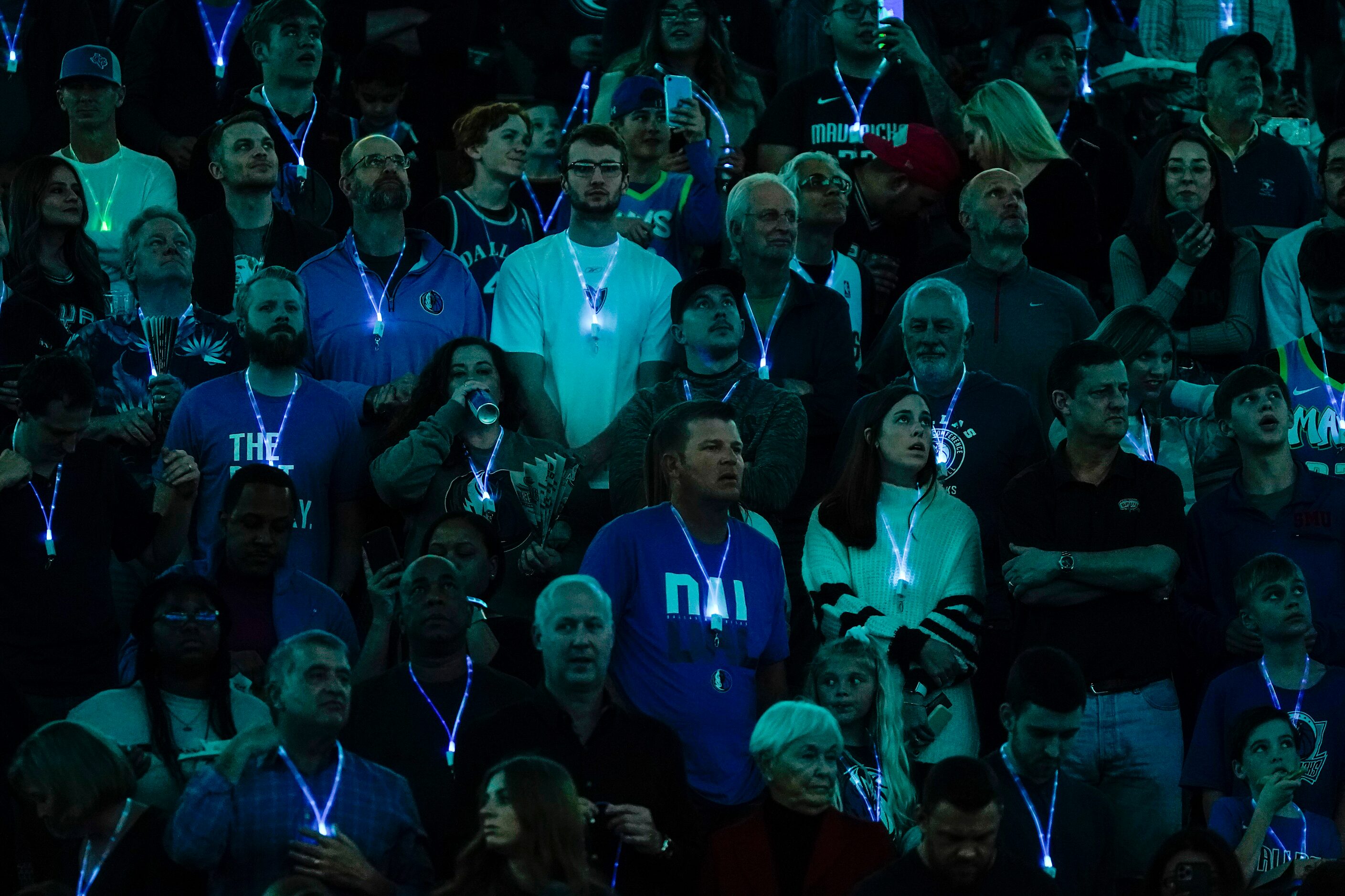 Fans wear lighted necklaces before an NBA basketball game between the Dallas Mavericks and...