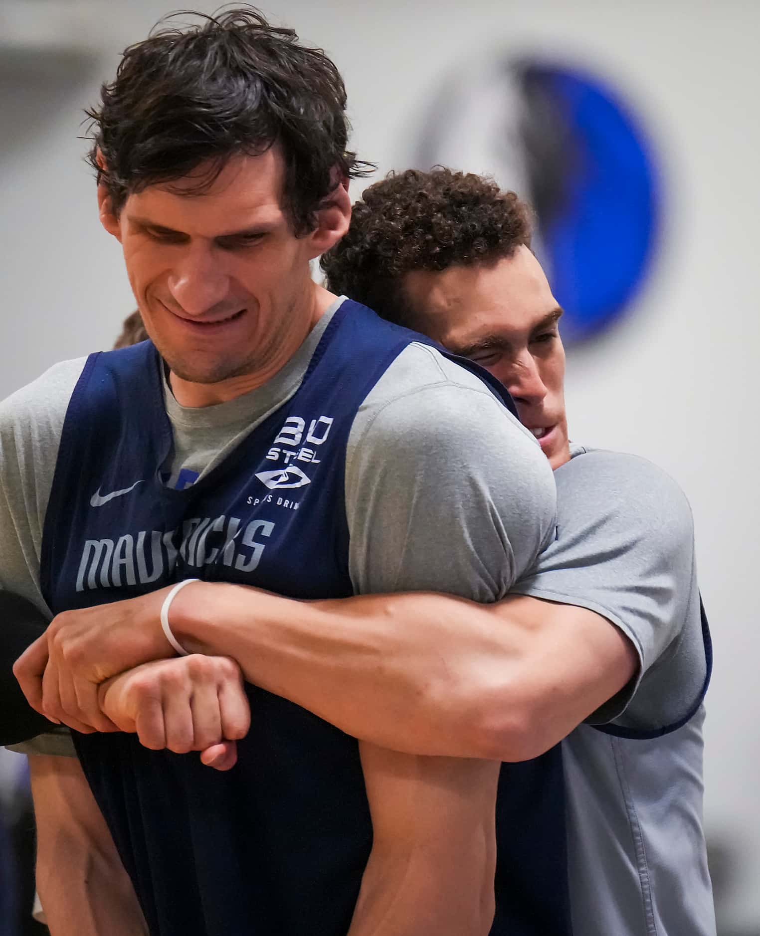 Dallas Mavericks center Dwight Powell wraps his arms around center Boban Marjanovic as the...