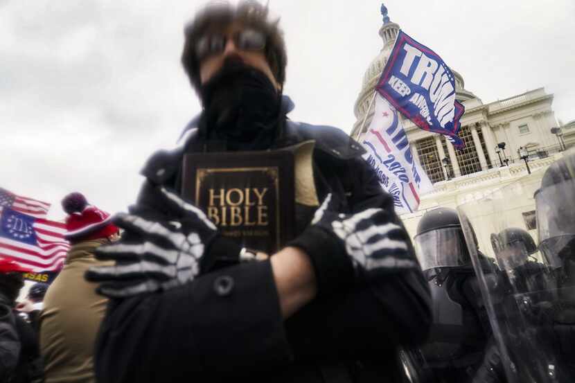 A man holds a Bible as Trump supporters gathered at the Capitol in Washington on Jan. 6, 2021.