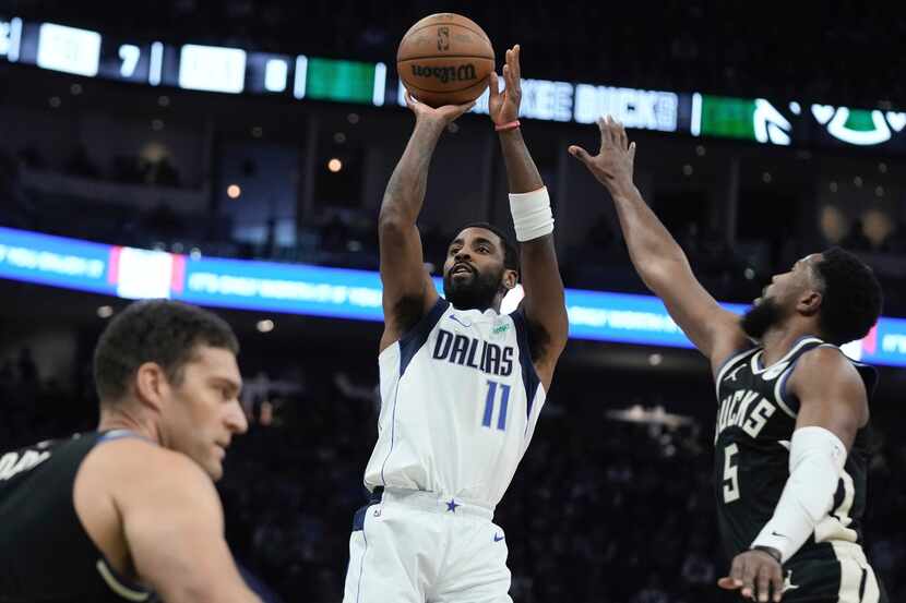 Dallas Mavericks' Kyrie Irving shoots past Milwaukee Bucks' Malik Beasley during the first...