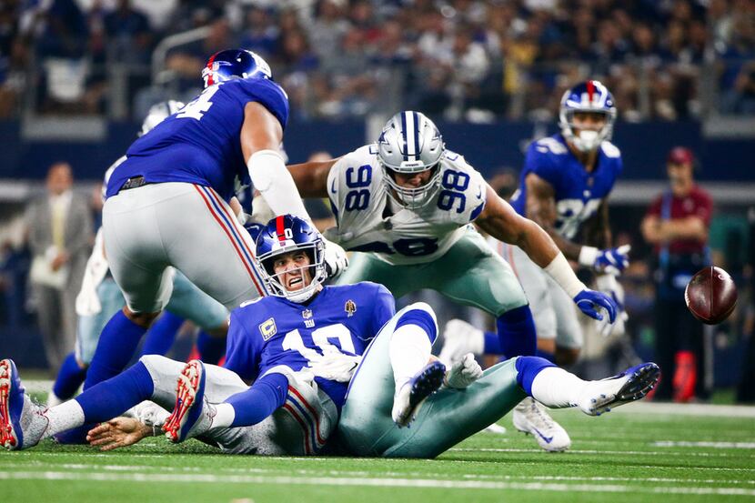 New York Giants quarterback Eli Manning (10) fumbles the ball after getting sacked by...