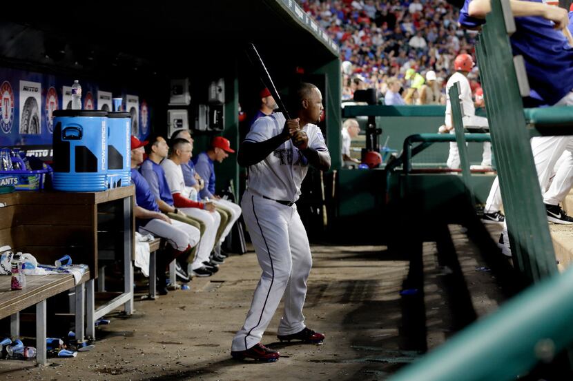 Texas Rangers' Adrian Beltre motions through his swing while standing in the dugout in the...