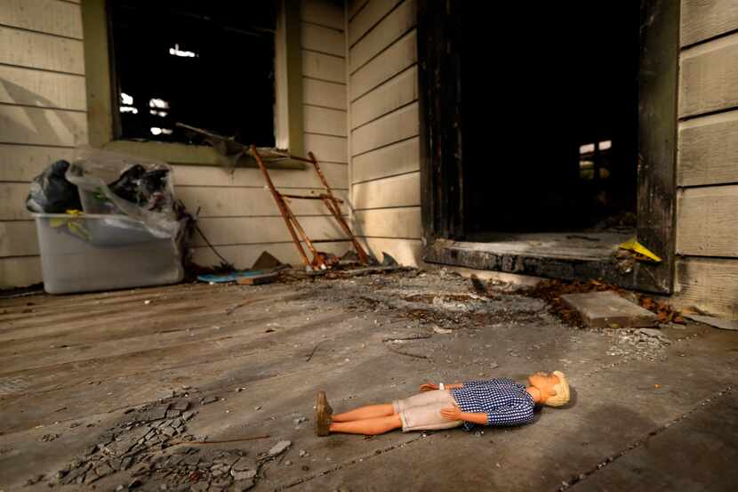 A doll lies on the front porch of a burned out home on Durango Dr., Friday, March 8, 2019....