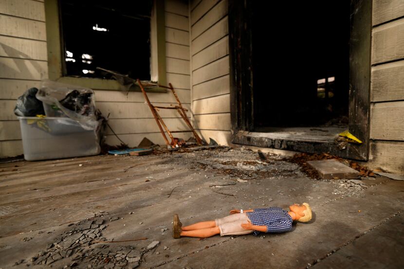 A doll lies on the front porch of a burned out home on Durango Drive, March 8, 2019. The...