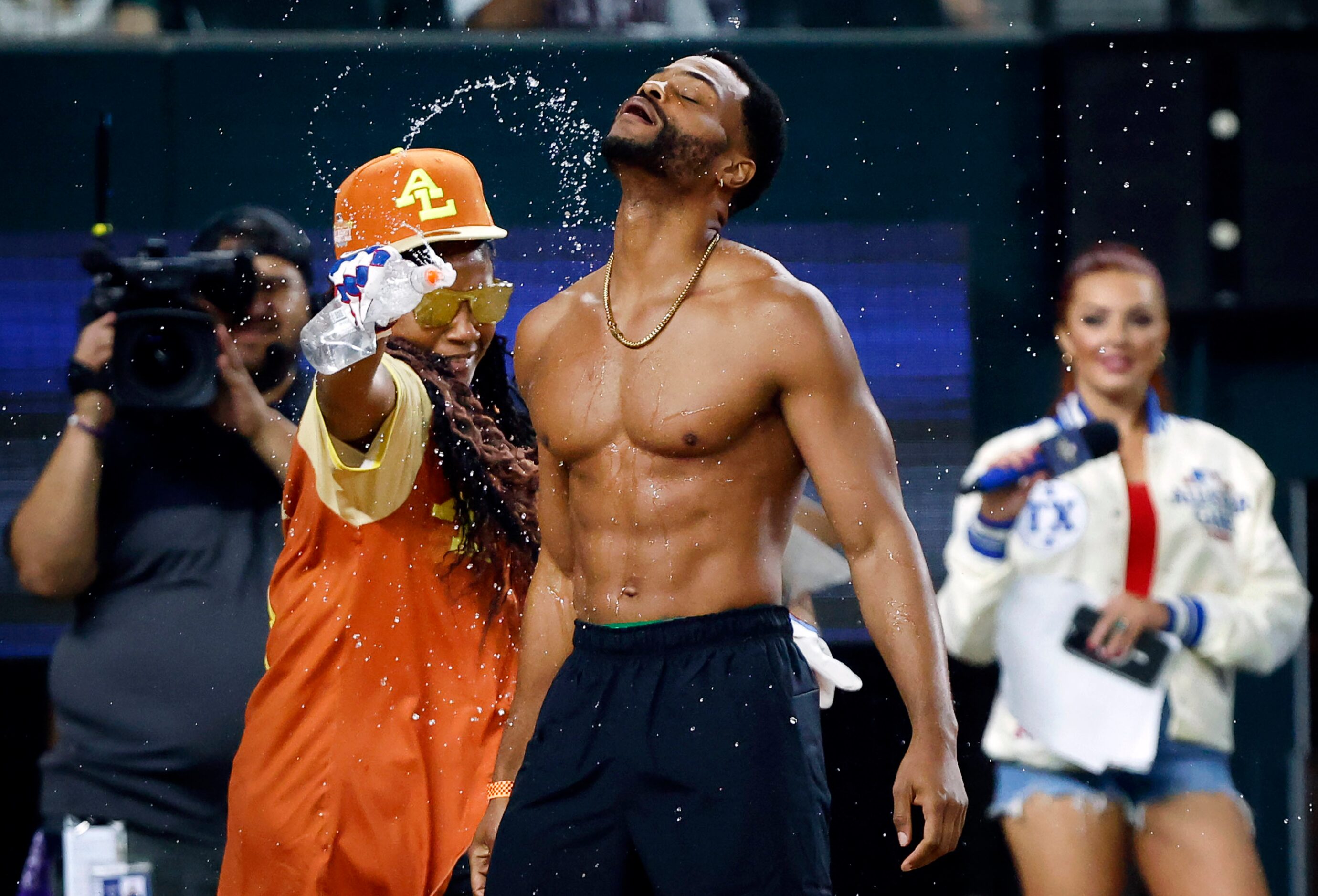 Comedian King Bach rips off his jersey as Tiffany Haddish (24) cools him down during a first...