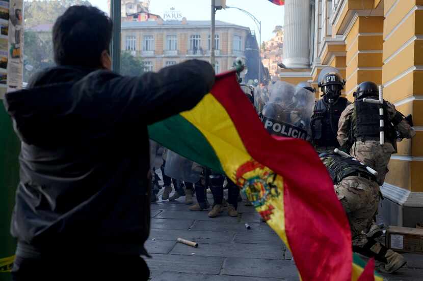 Un seguidor del presidente boliviano, Luis Arce, ondea una bandera de Bolivia ante la...