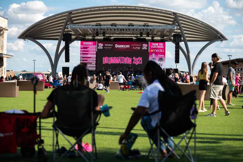 Concertgoers use their own lawn chairs while sitting on the green turf during Drummathon at...